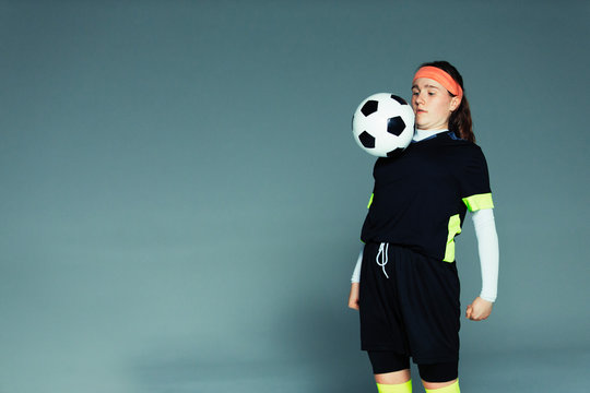 Teenage girl soccer player balancing ball on chest