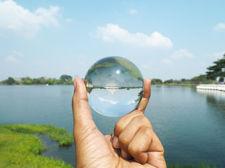 hand holding crystal ball at Suan Luang Rama IX Public Park in Bangkok, Thailandat.