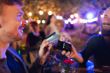 Man with credit card paying bartender at party