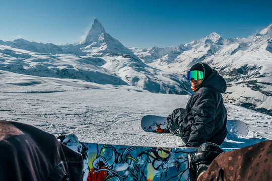 Personal perspective snowboarders on snowy ski slope, Zermatt, Switzerland