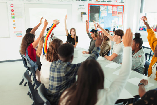 High School Students With Hands Raised In Debate Class