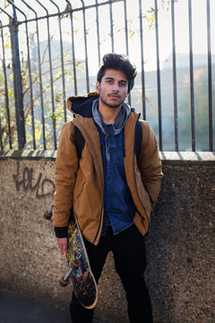 Portrait confident young man holding skateboard