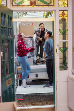 Friends laughing at back of moving van