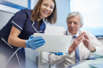Doctor and nurse using digital tablet in clinic doctors office