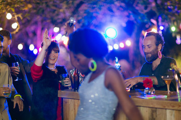 Friends dancing and drinking at garden party