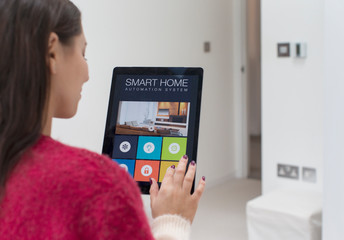 Woman using smart home automation system with digital tablet