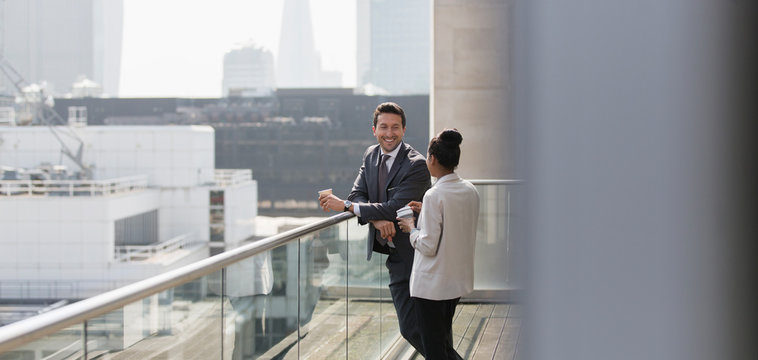 Business people talking on sunny, urban balcony