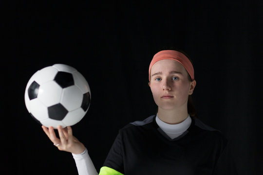 Portrait confident, determined teenage girl soccer player holding soccer ball