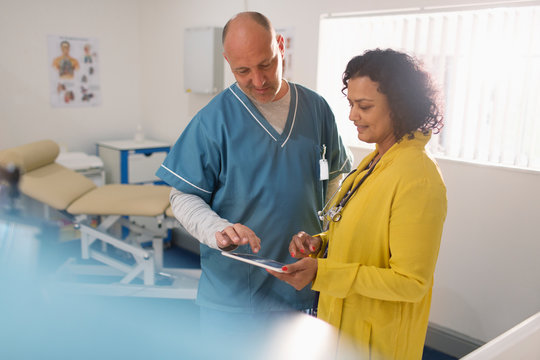 Doctors using digital tablet in doctors office