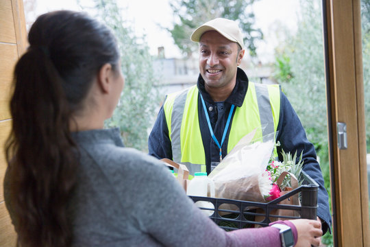 Woman Greeting Food Deliveryman At Front Door