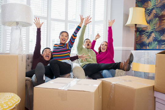 Portrait playful friends taking a break from moving, celebrating and cheering