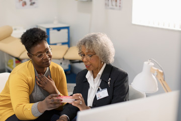 Female doctor prescribing medication to patient in doctors office