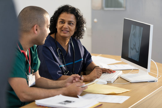 Doctors looking at digital x-ray on computer in doctors office