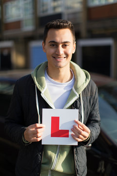 Portrait happy, confident young man holding learner permit