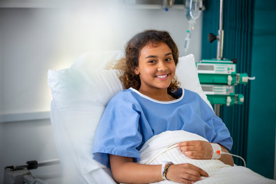 Portrait smiling girl patient in hospital bed