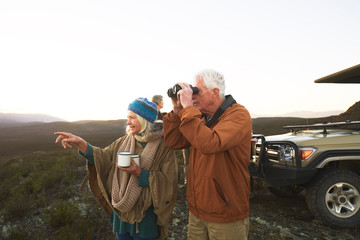Senior couple with binoculars and tea on safari South Africa