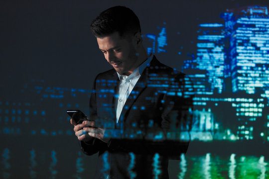 Double exposure businessman using smart phone against highrise lights at night - Powered by Adobe