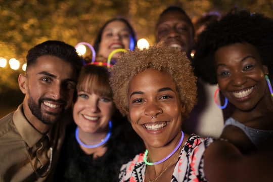 Portrait happy friends wearing neon at party