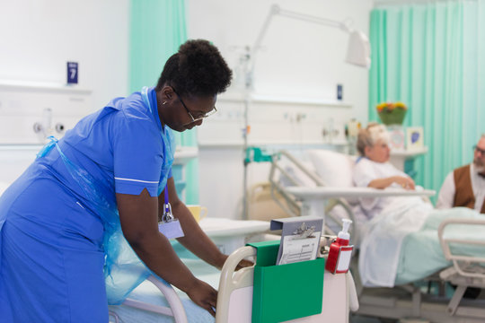 Female nurse making hospital bed
