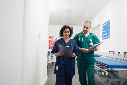 Doctors with medical chart making rounds in hospital corridor