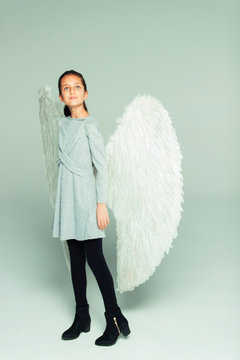 Portrait hopeful, ambitious girl wearing angel wings