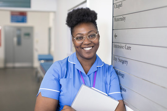 Portrait smiling, confident female nurse in hospital corridor