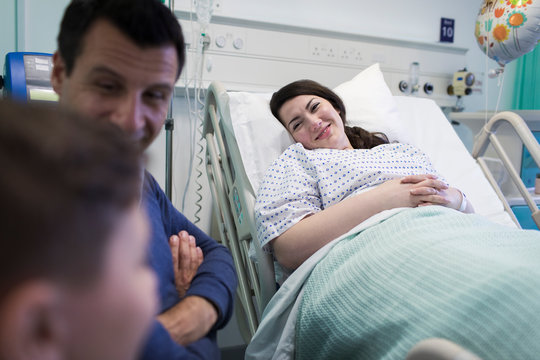 Smiling patient visiting with family in hospital room