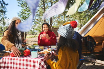Family eating at campsite picnic table