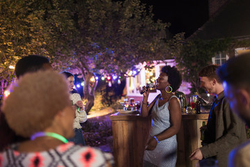 Young woman with microphone singing at garden party