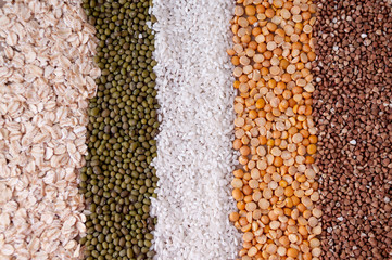 Background in a strip of cereals oatmeal, mash, rice, peas and buckwheat on the table, top view