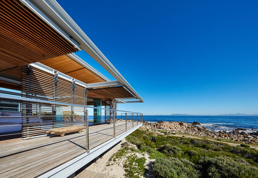 Modern luxury home showcase with ocean view under sunny blue sky