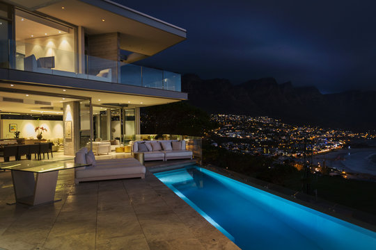 Illuminated Luxury Home Showcase Exterior With Lap Pool At Night