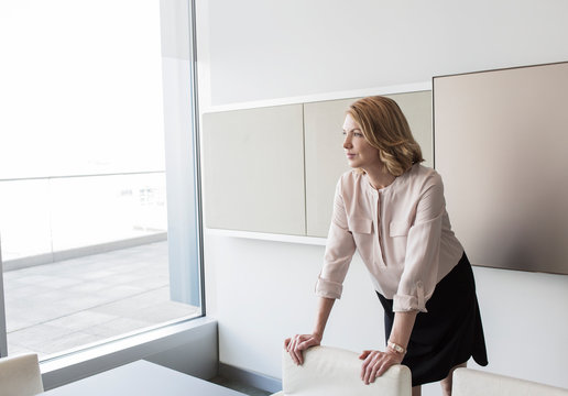 Pensive businesswoman looking out office window