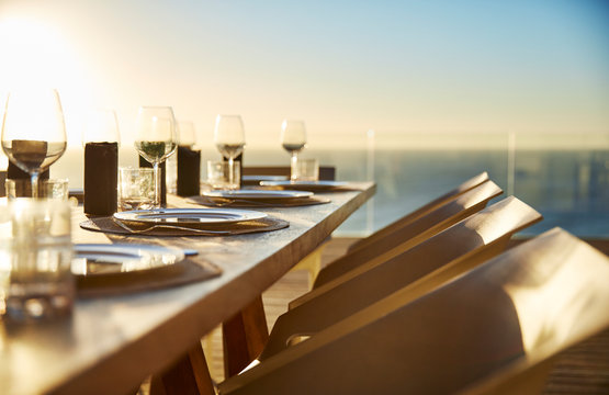 Sunset behind placesettings on luxury patio dining table