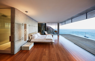 Modern luxury bedroom open to patio with ocean view