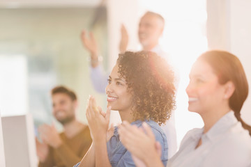 Businesswomen clapping in office