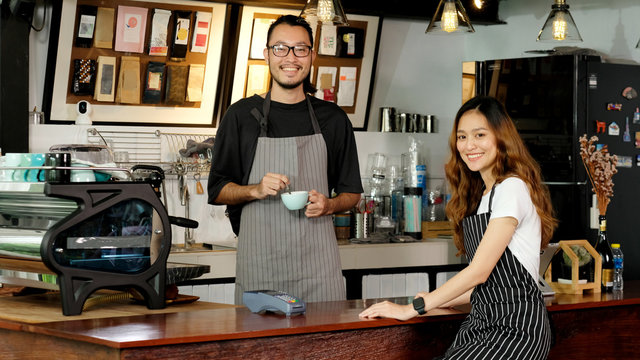 Asia Small Business Owner, Happy Asian Man, Woman Barista, Waiter, Waitress Smiling In Font Of Coffee Shop Cafe Counter, Male And Female Partnership In Start Up New Food And Drink Industry