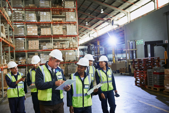 Manager and workers talking in distribution warehouse
