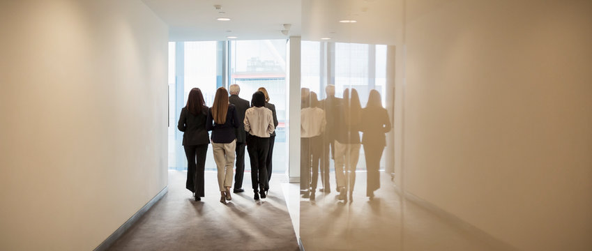 Business people walking in office corridor