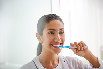 Woman brushing teeth with toothbrush