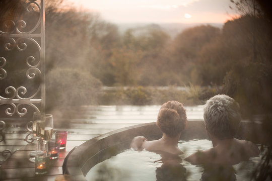 Serene couple in hot tub looking at autumn tree view