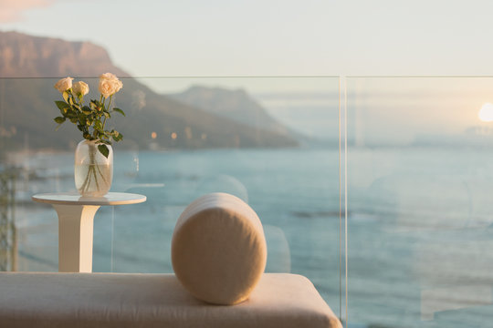 Tranquil ocean view from luxury balcony with chaise lounge and rose bouquet