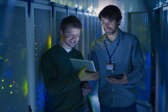 Server room technicians using digital tablet