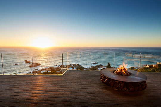 Fire pit on luxury patio with sunset ocean view