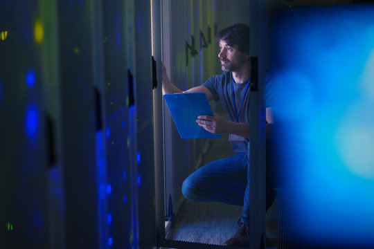 Server room technician with clipboard