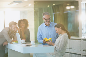 Businessman giving gift to businesswoman in office