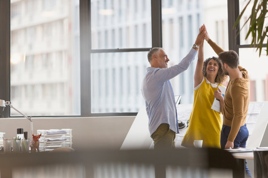 Architects high fiving in office