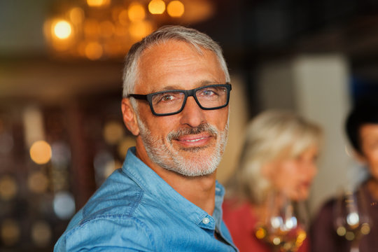 Portrait confident man with eyeglasses at bar