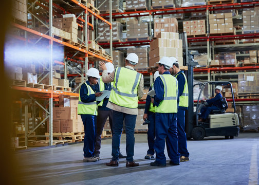 Manager and workers meeting in distribution warehouse