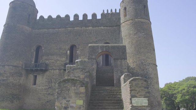 Forward push-in climbing up the rear steps of Fasilides Castle to the entrance door in Gondar, Ethiopia